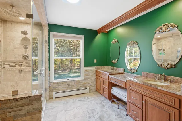 a spacious bathroom with a granite countertop sink a mirror and a shower