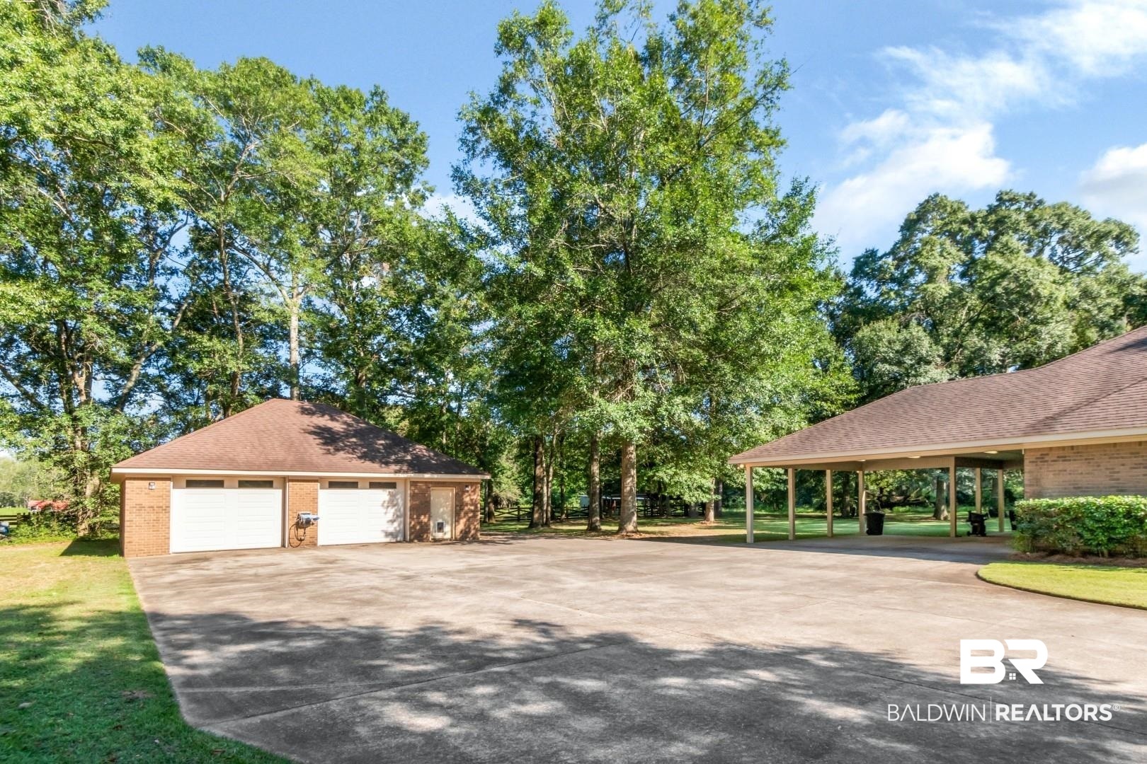 1360 Dykes Road North Mobile, AL 36608 - Photo 3 of 40 View of side of home with brick siding, roof with shingles, an outdoor structure, and view of wooded area