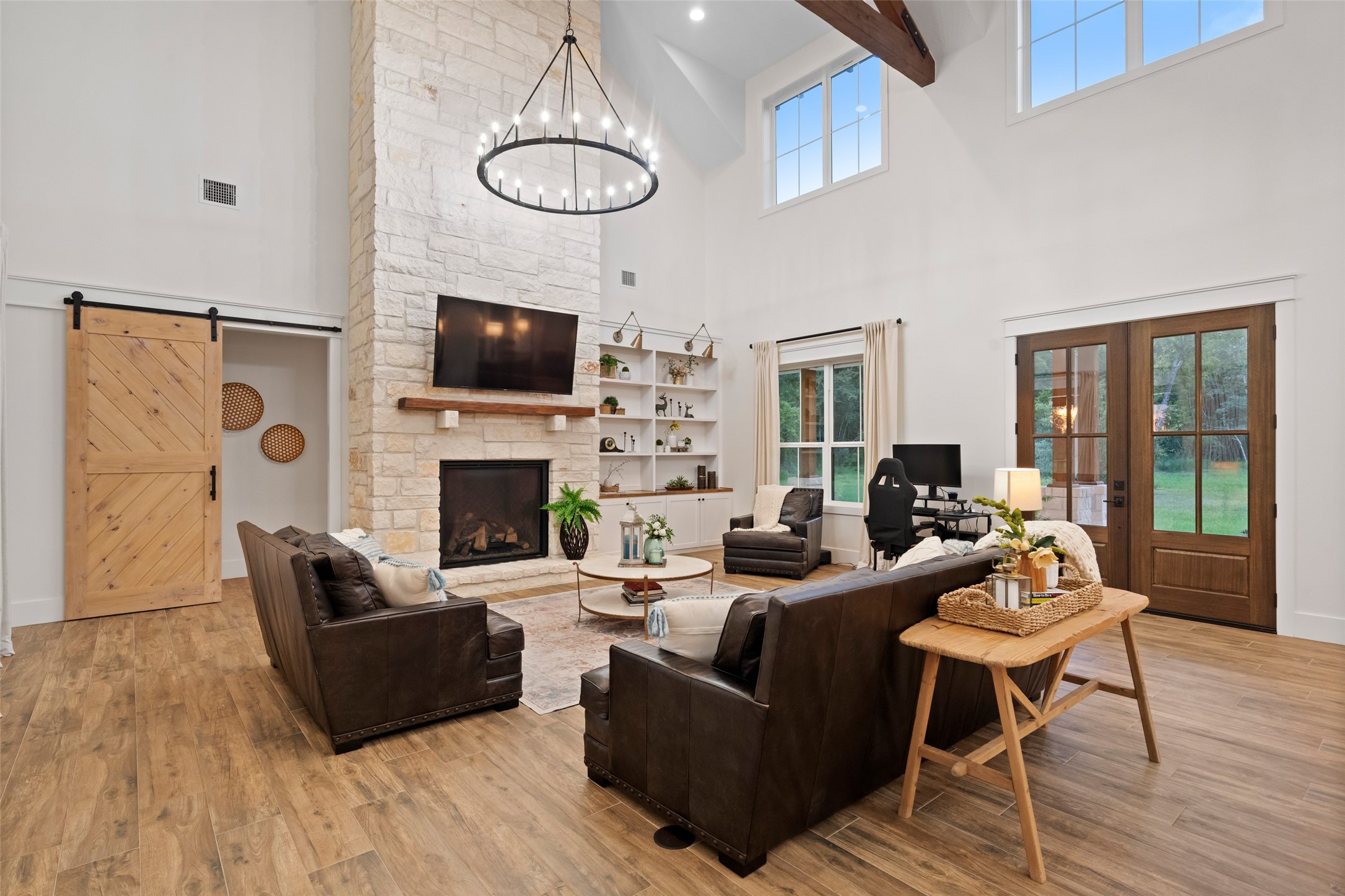 27201 Double Culvert Road Hempstead, TX 77445 - Photo 13 of 49 The main living room boasts a soaring stone fireplace, wood beams, and wide-plank tile floors, creating a dramatic yet comfortable focal point.