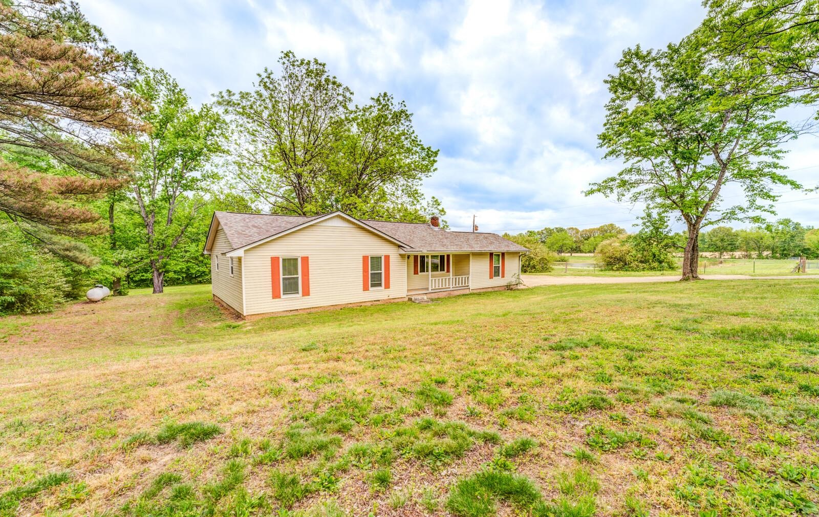 6125 Warren Road Oakland, TN 38060 - Photo 2 of 40 Single-story residence featuring light-colored siding, a covered front porch with white columns, and red decorative shutters