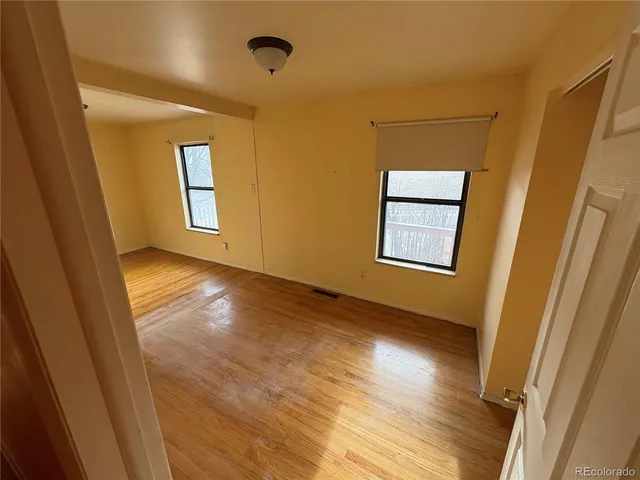 a view of a room with wooden floor and windows