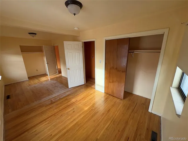a view of empty room with wooden floor