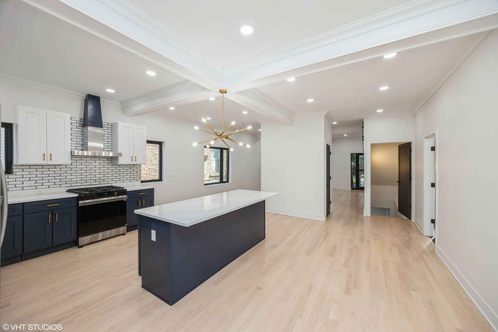 2230 South Ridgeway Avenue Chicago, IL 60623 - Photo 6 of 13 a large white kitchen with stainless steel appliances kitchen island granite countertop a large counter top and a stove top oven