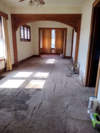 a view of an empty room with a fireplace and a window