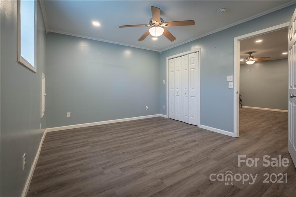 3604 Deerbrook Road Lenoir, NC 28645 - Photo 17 of 21 an empty room with wooden floor and chandelier fan