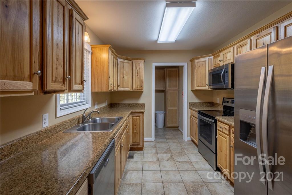 3604 Deerbrook Road Lenoir, NC 28645 - Photo 6 of 21 a kitchen with stainless steel appliances granite countertop a sink stove and refrigerator