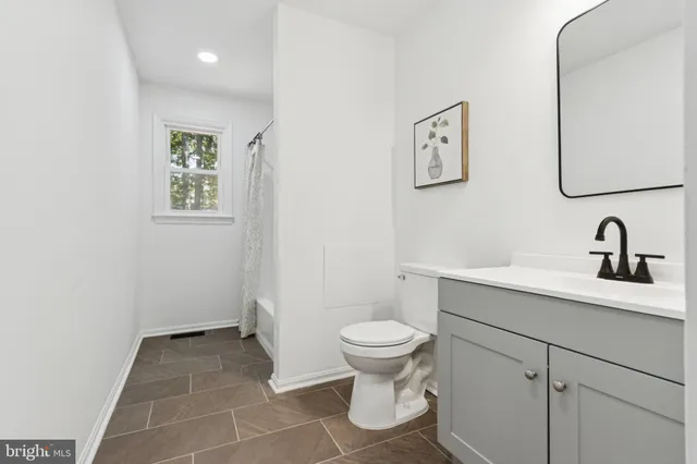 a bathroom with a sink toilet and a mirror