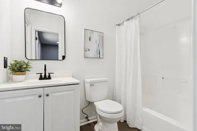 a bathroom with a toilet sink vanity and mirror