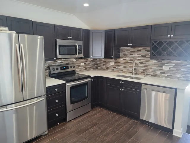 a kitchen with stainless steel appliances granite countertop a refrigerator stove a sink and dishwasher