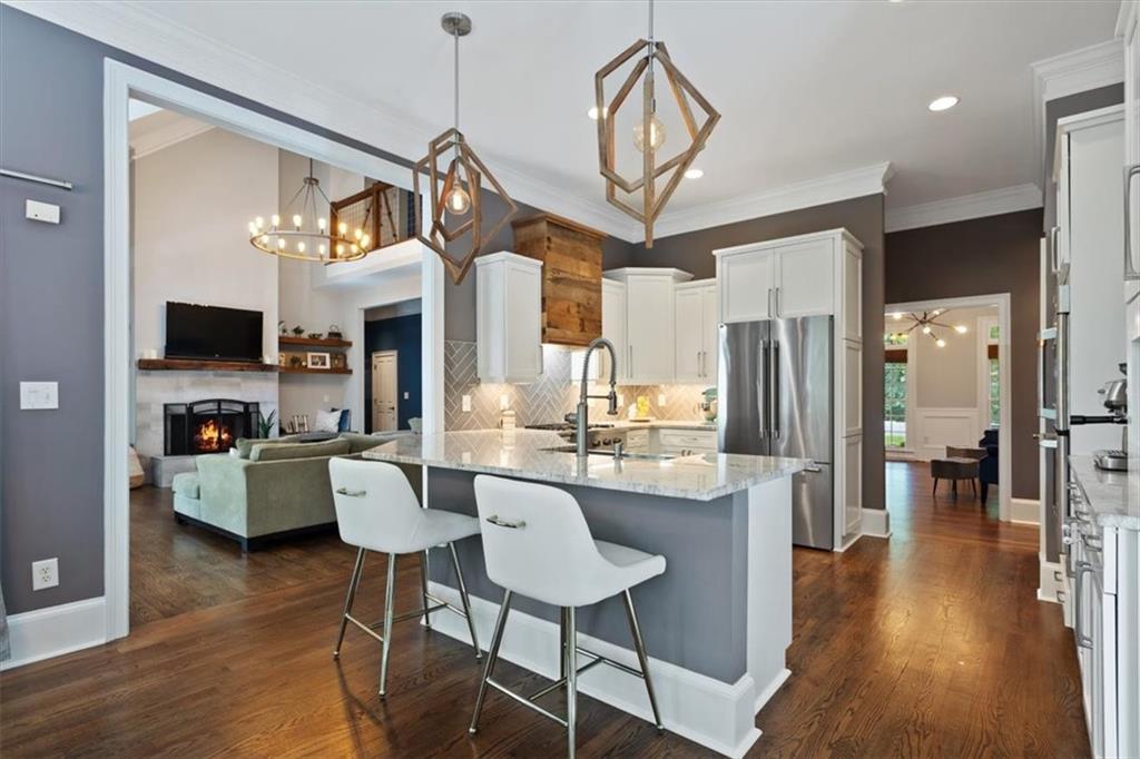 134 Prospector Ridge Dahlonega, GA 30533 - Photo 30 of 96 a kitchen with stainless steel appliances kitchen island granite countertop a table chairs refrigerator and microwave