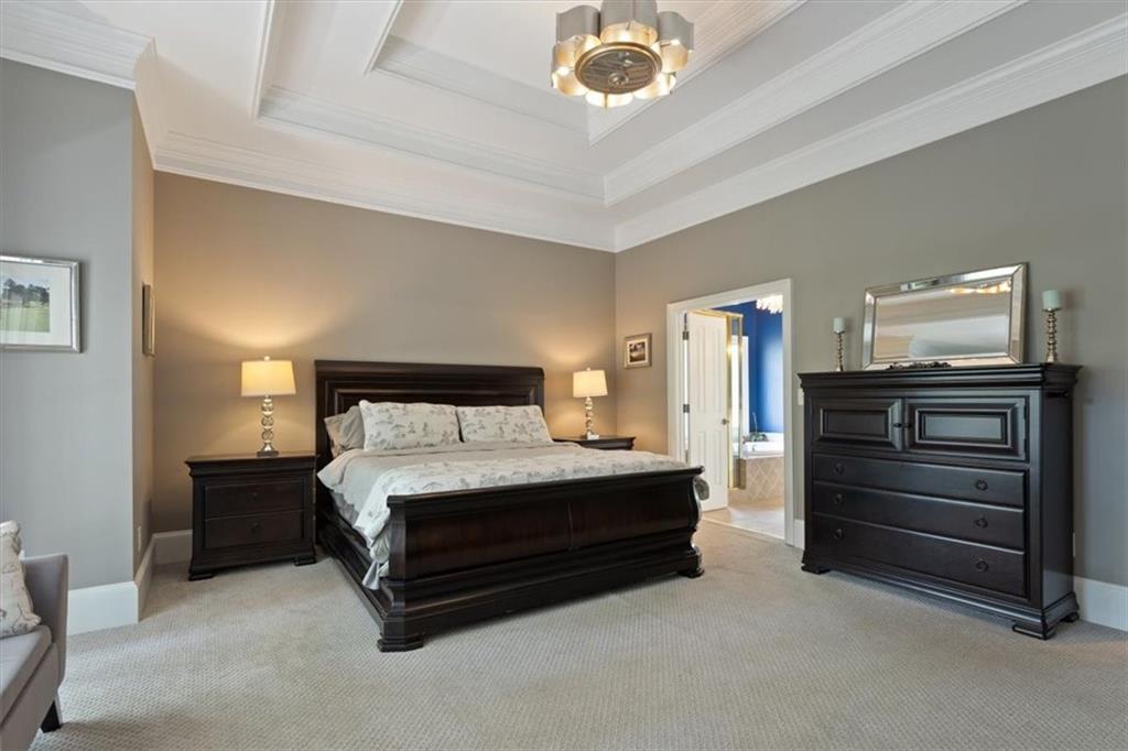 134 Prospector Ridge Dahlonega, GA 30533 - Photo 33 of 96 a spacious bedroom with a bed and a chandelier