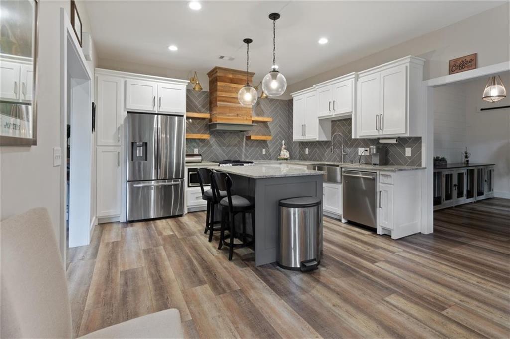 134 Prospector Ridge Dahlonega, GA 30533 - Photo 65 of 96 a kitchen with stainless steel appliances granite countertop a sink a stove a refrigerator and island with wooden floor
