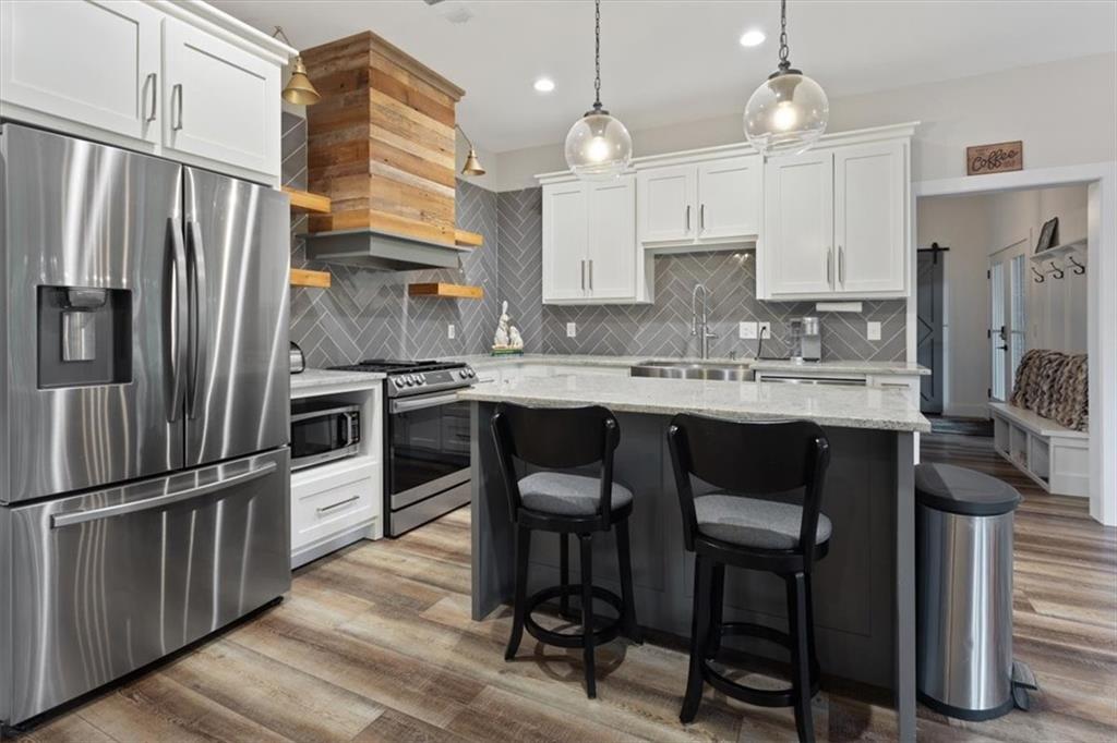 134 Prospector Ridge Dahlonega, GA 30533 - Photo 66 of 96 a kitchen with stainless steel appliances kitchen island granite countertop a table chairs and a refrigerator