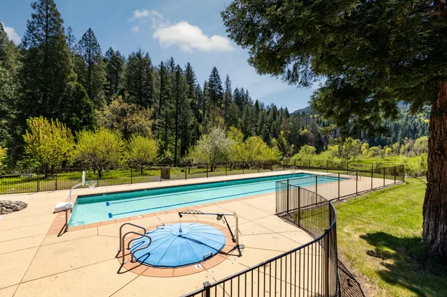 a view of a swimming pool with a patio and yard