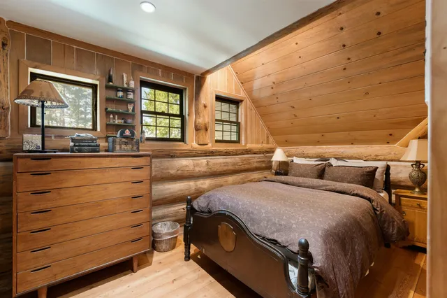 a bedroom with a bed and large windows