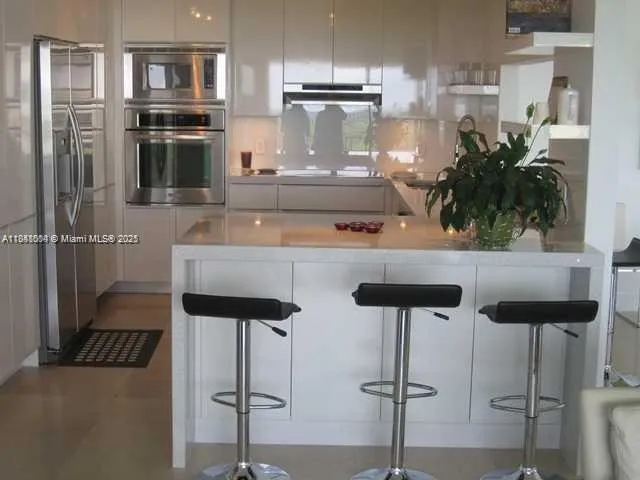 a kitchen with stainless steel appliances kitchen island granite countertop a refrigerator and a stove top oven