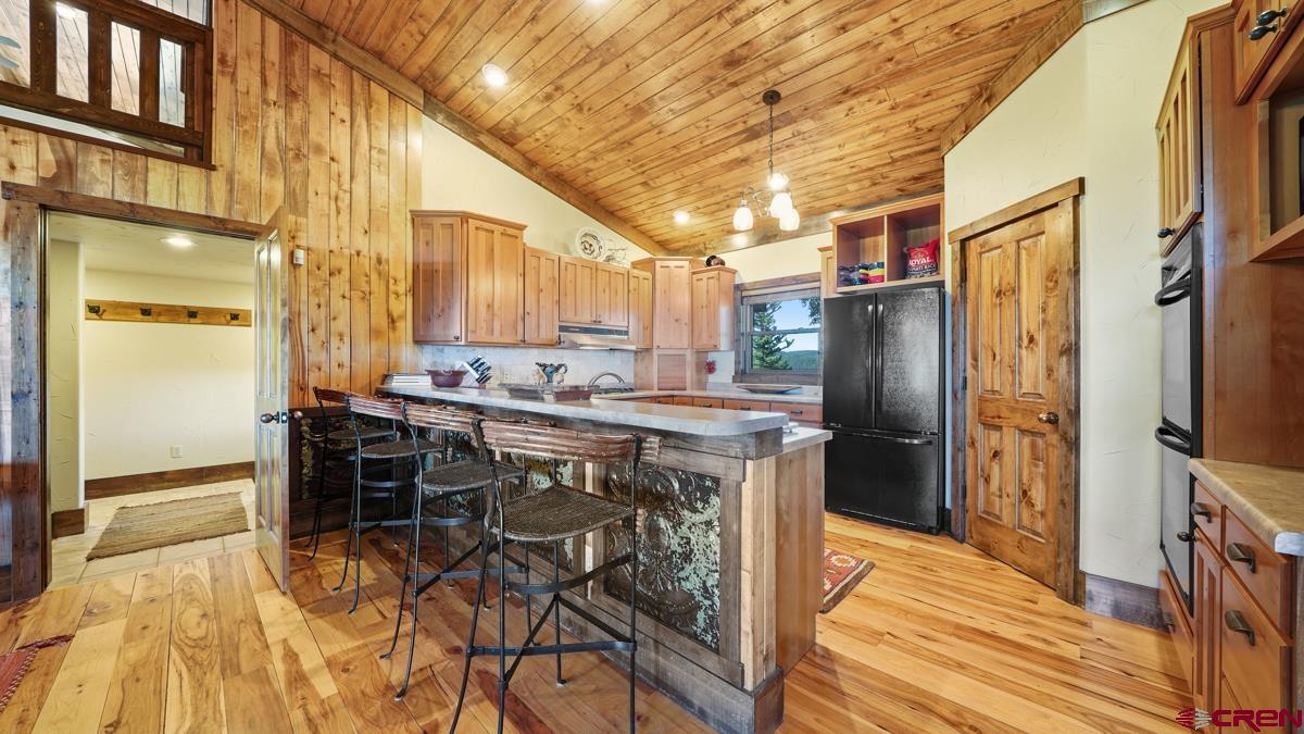 220 Ridge Road Cimarron, CO 81220 - Photo 11 of 45 a kitchen with a table chairs refrigerator and cabinets
