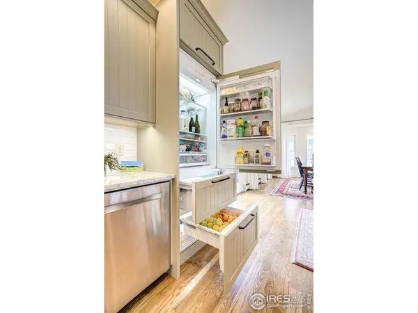 a living room with stainless steel appliances kitchen island granite countertop a sink and cabinets