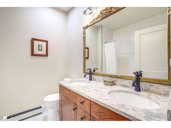a bathroom with a granite countertop sink a toilet and a mirror