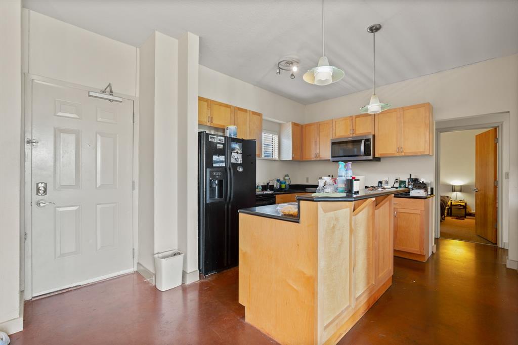 711 West 26th Street, Unit 700 Austin, TX 78705 - Photo 4 of 19 a kitchen with stainless steel appliances granite countertop a refrigerator a stove top oven a sink and dishwasher with wooden floor