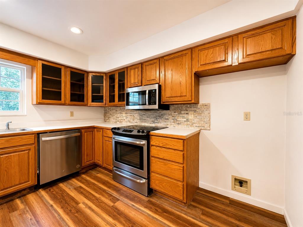 7119 Immokalee Road Keystone Heights, FL 32656 - Photo 16 of 50 a kitchen with stainless steel appliances granite countertop a stove a sink and a microwave
