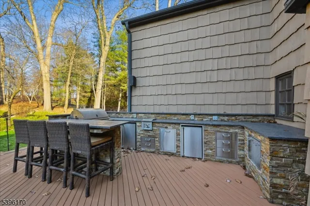 a view of a patio with table and chairs with wooden floor and fence