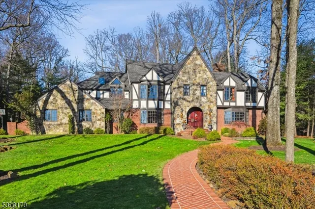 a view of a house with a big yard and large trees
