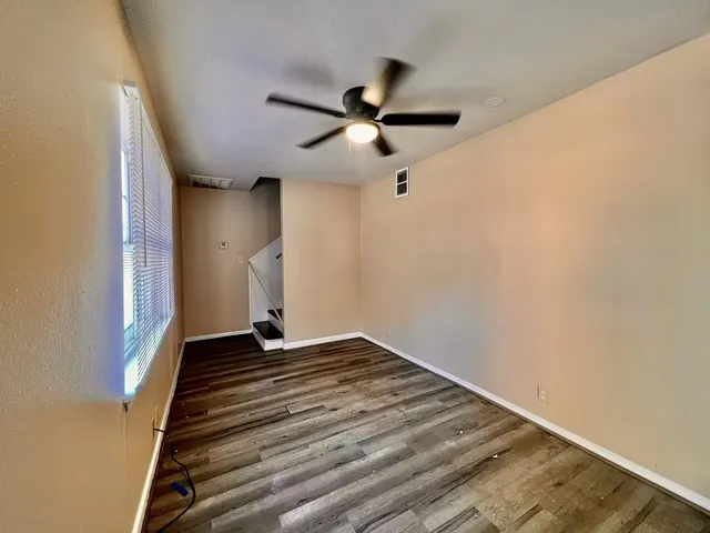 a view of empty room with wooden floor