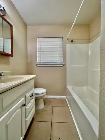 a bathroom with a granite countertop sink a toilet and bathtub