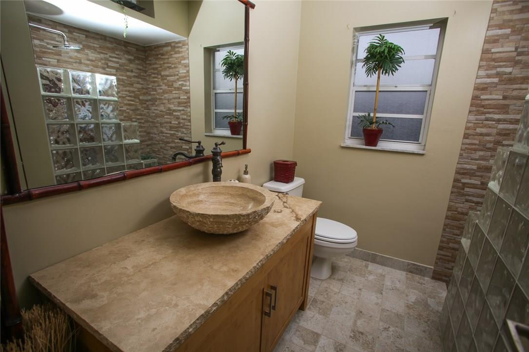 5001 Southwest 164th Terrace Southwest Ranches, FL 33331 - Photo 12 of 24 a bathroom with a granite countertop sink a toilet and mirror