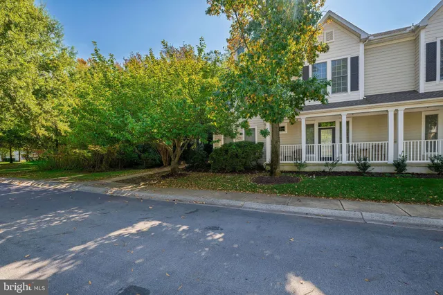 a view of a house with a yard and large trees