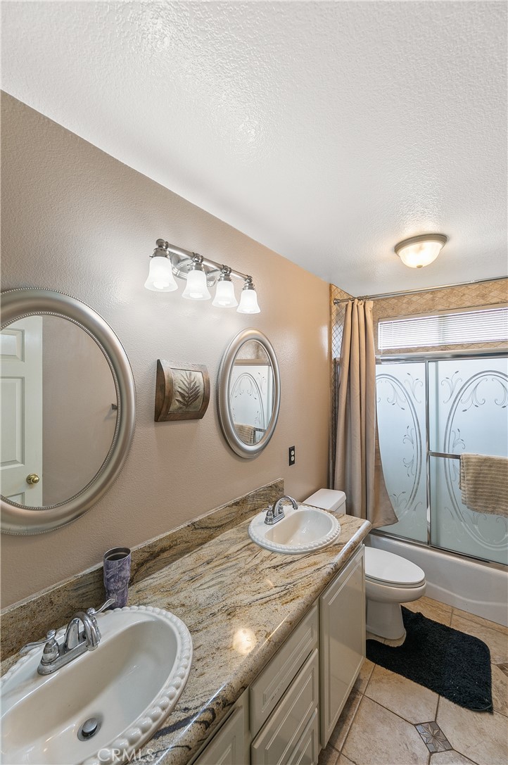 26266 Beecher Lane Stevenson Ranch, CA 91381 - Photo 18 of 25 a bathroom with a granite countertop toilet sink and mirror