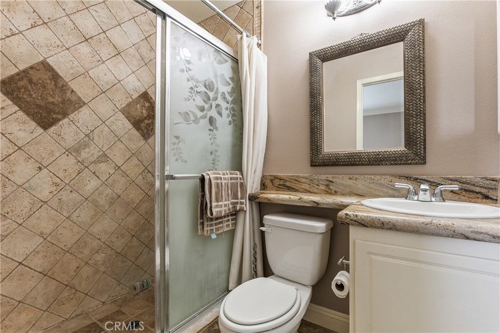 26266 Beecher Lane Stevenson Ranch, CA 91381 - Photo 20 of 25 a bathroom with a granite countertop toilet sink and mirror