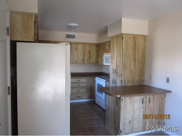 912 Forest Hylands Road, Unit 1 Prescott, AZ 86303 - Photo 2 of 10 a kitchen with kitchen island cabinets and refrigerator