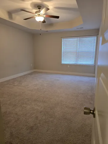 an empty room with windows and fan