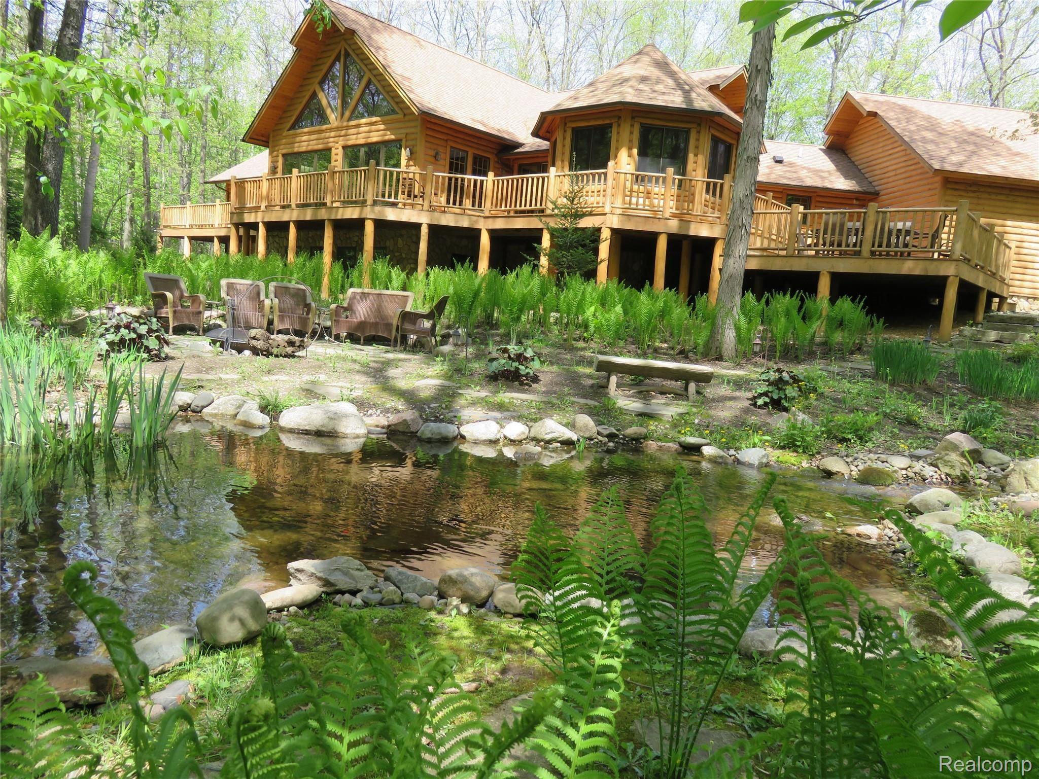 701 Argentine Road Howell, MI 48843 - Photo 4 of 45 Back Yard View of Pond and Fire Pit Patio Area in Summer