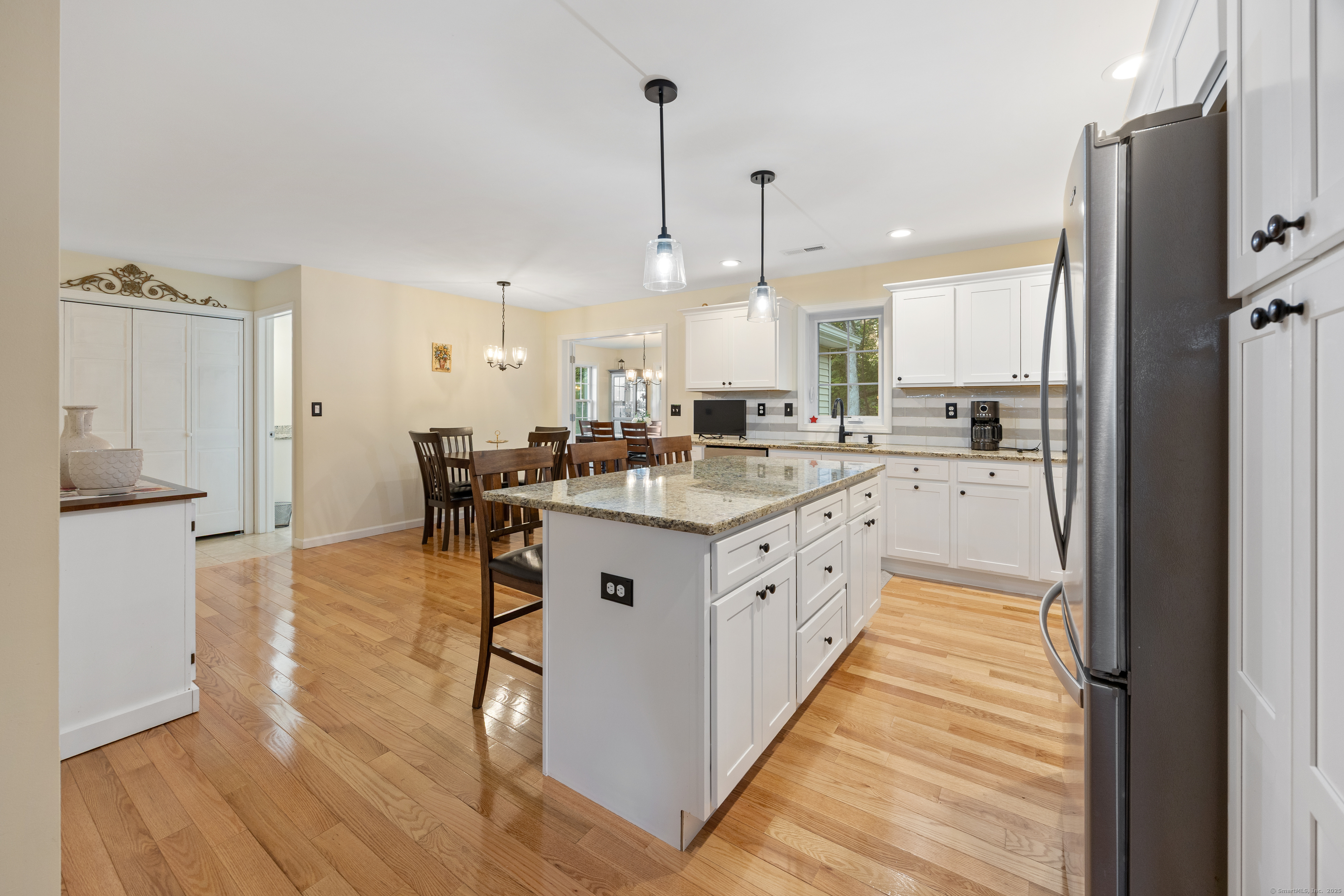 29 Hannah Way Harwinton, CT 06791 - Photo 10 of 34 a large white kitchen with stainless steel appliances granite countertop a stove a sink a refrigerator and island with wooden floor