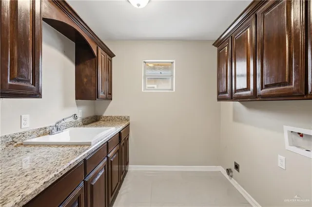 a bathroom with a granite countertop sink and a window