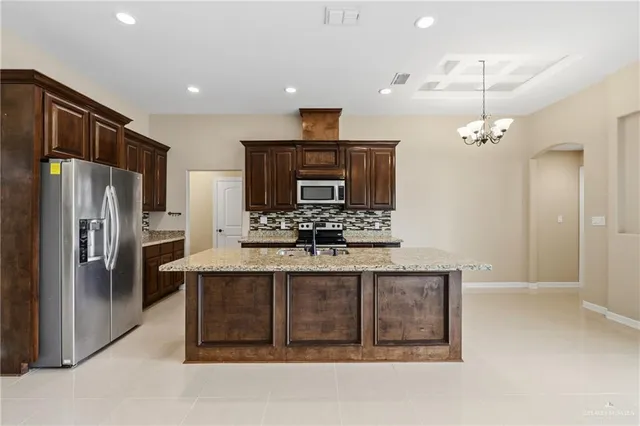 a kitchen with stainless steel appliances a refrigerator and a stove top oven