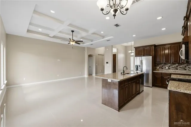 a kitchen with stainless steel appliances granite countertop a sink and a refrigerator