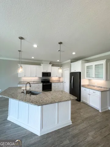 a kitchen with stainless steel appliances granite countertop a sink a refrigerator and a granite counter tops