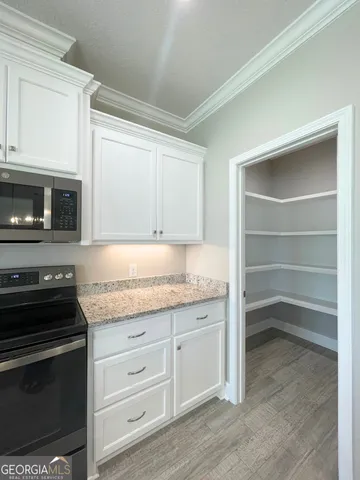 a kitchen with granite countertop a stove and a microwave