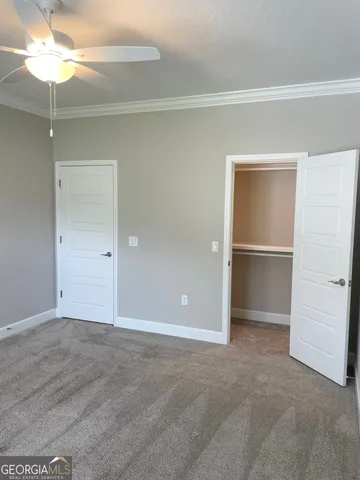 an empty room with closet and a chandelier fan