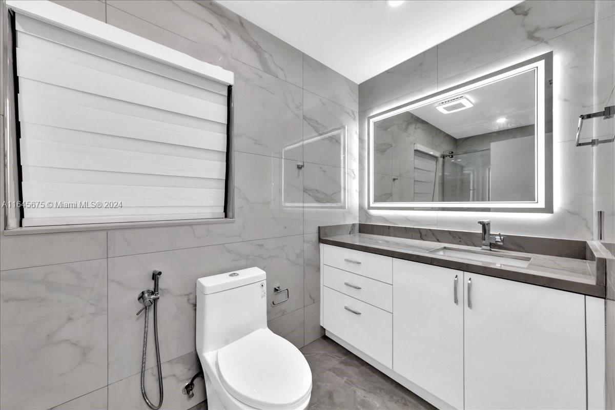 2373 Southwest 177th Terrace Miramar, FL 33029 - Photo 11 of 79 a bathroom with a granite countertop toilet sink and mirror