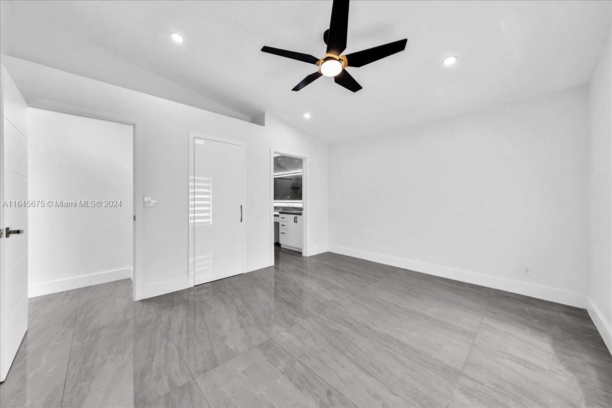 2373 Southwest 177th Terrace Miramar, FL 33029 - Photo 26 of 79 an empty room with wooden floor cabinet and windows