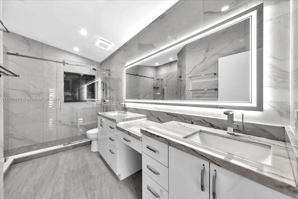 2373 Southwest 177th Terrace Miramar, FL 33029 - Photo 32 of 79 a spacious bathroom with a double vanity sink a mirror and a shower