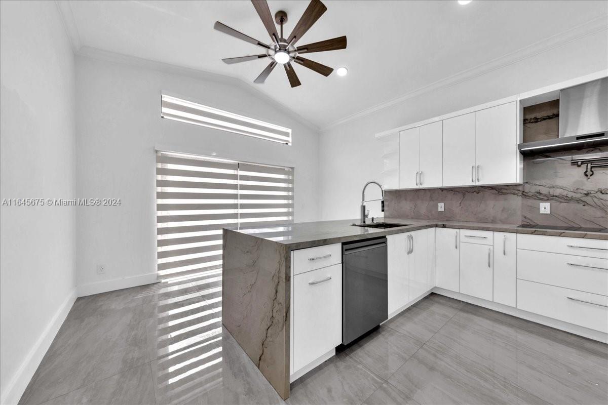 2373 Southwest 177th Terrace Miramar, FL 33029 - Photo 38 of 79 a kitchen with stainless steel appliances granite countertop a stove a sink and white cabinets