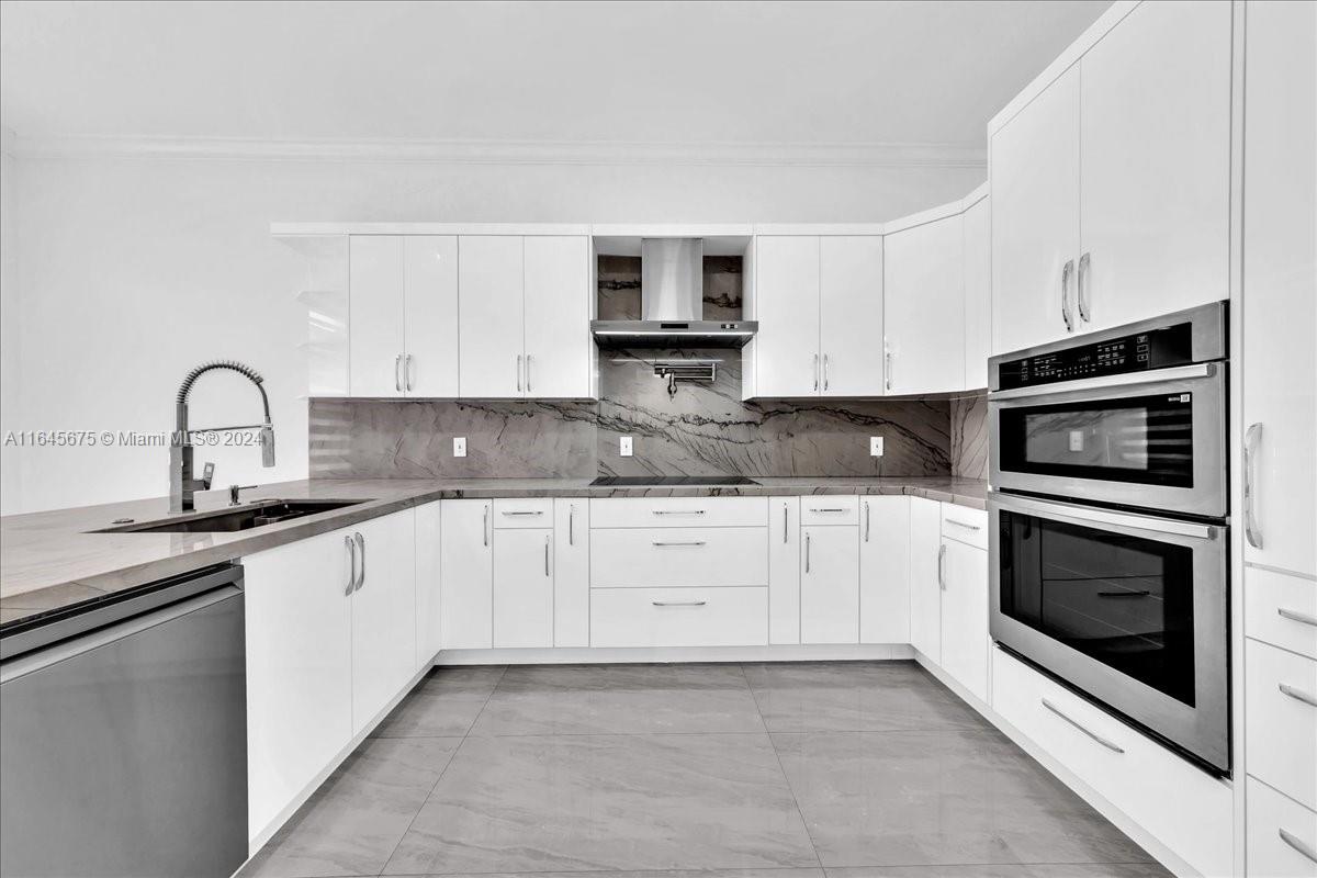 2373 Southwest 177th Terrace Miramar, FL 33029 - Photo 39 of 79 a kitchen with stainless steel appliances granite countertop a stove top oven and sink