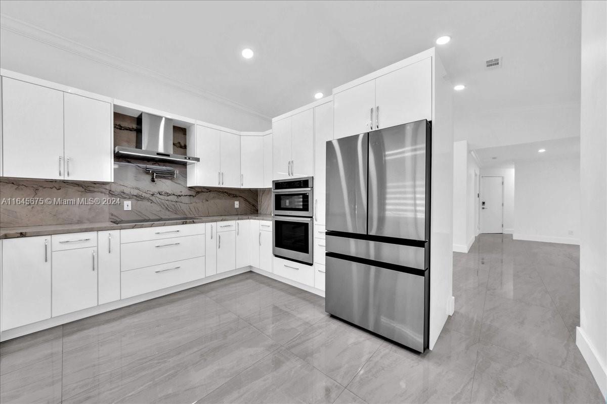 2373 Southwest 177th Terrace Miramar, FL 33029 - Photo 40 of 79 a kitchen with stainless steel appliances granite countertop a refrigerator and a stove top oven