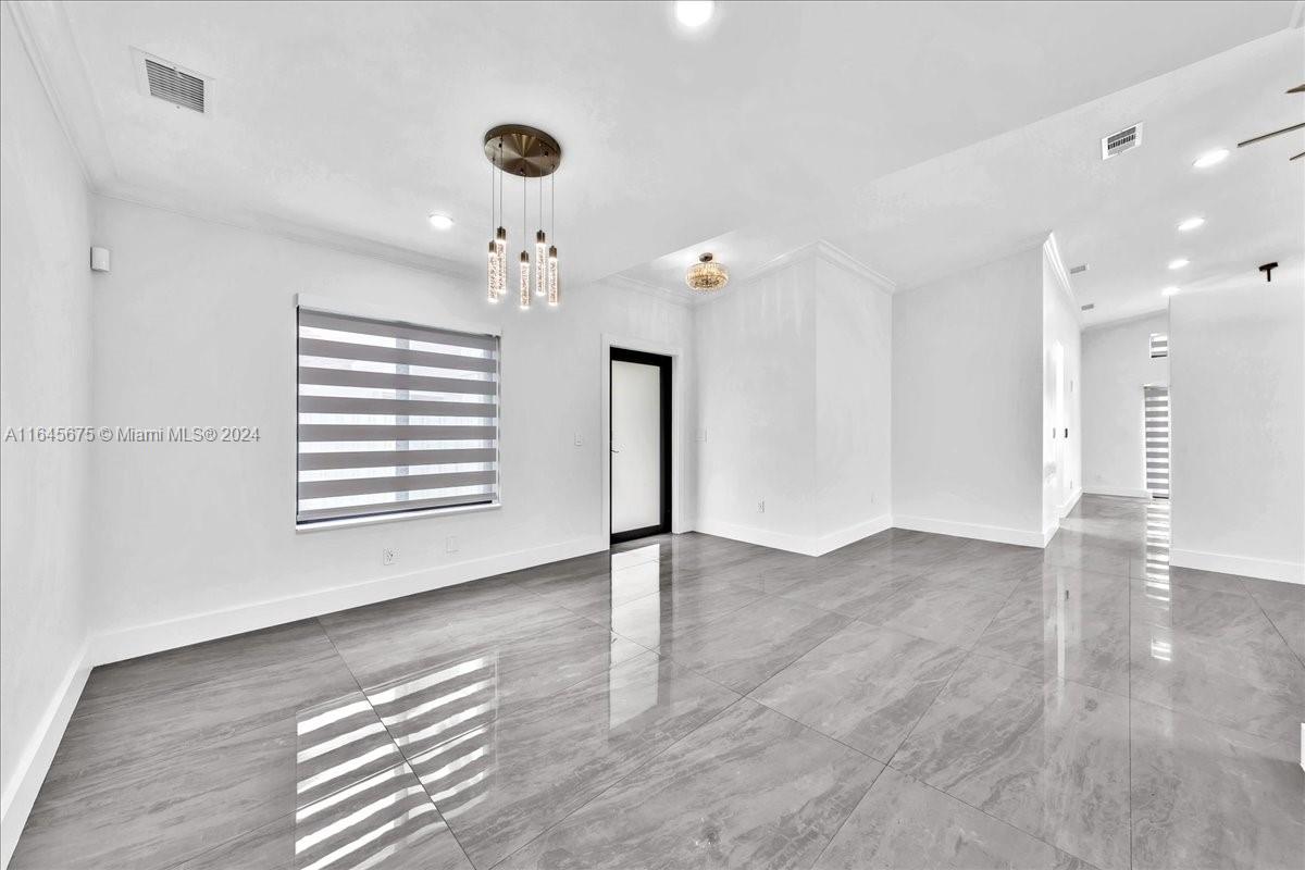 2373 Southwest 177th Terrace Miramar, FL 33029 - Photo 4 of 79 an empty room with wooden floor and windows